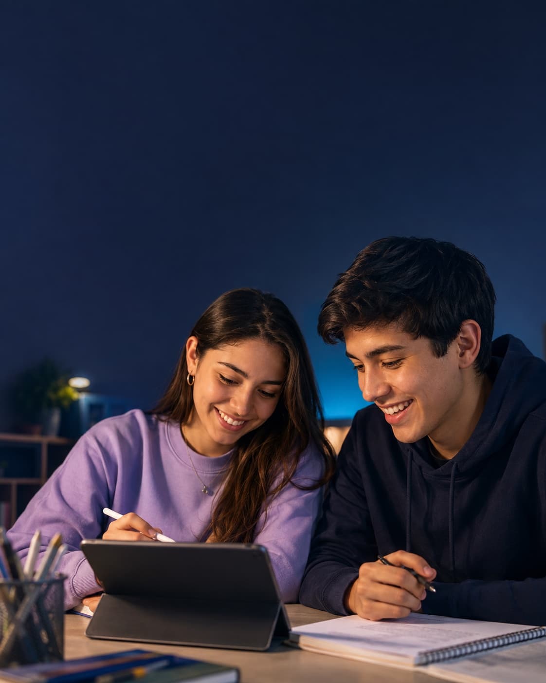 Dos estudiantes preparando juntos su próxima etapa con una tablet y sus apuntes.